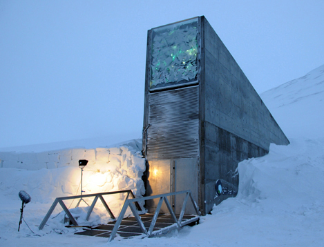 A tall structure with a bunker-like door that disappears into a snowbank