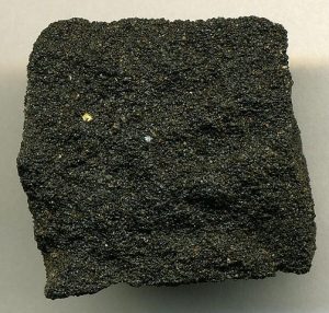The sandstone has a grainy appearance and is black with tar.