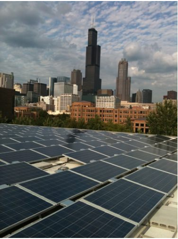 Rooftop solar installations are dark, flat panels with smaller cells inside them. The cityscape is visible in the background.