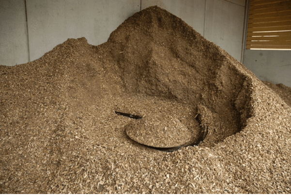 Photograph shows a pile of woodchips, which are a type of biomass
