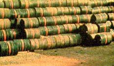 Stacks of green drums, each with an orange stripe in the middle