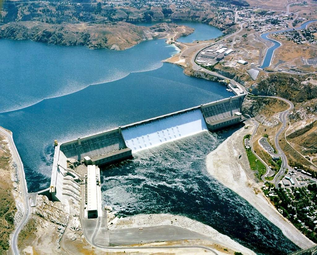 Aerial view of the Grand Coulee Dam showing a reservoir and the water entering the river below.