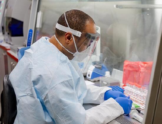Microbiologist Kerry Pollard performing manual extraction of coronavirus