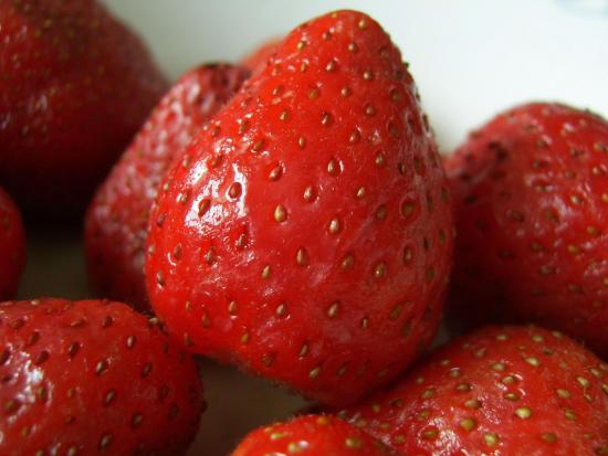 A strawberry with many seed-like structures stuck to the outside