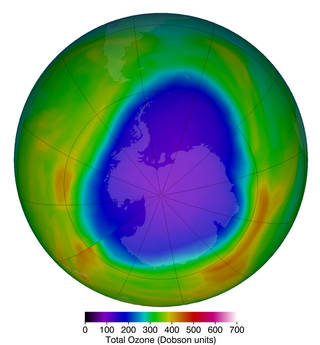 The ozone hole, represented by a dark purple gap in an otherwise green layer surrounding the Earth.
