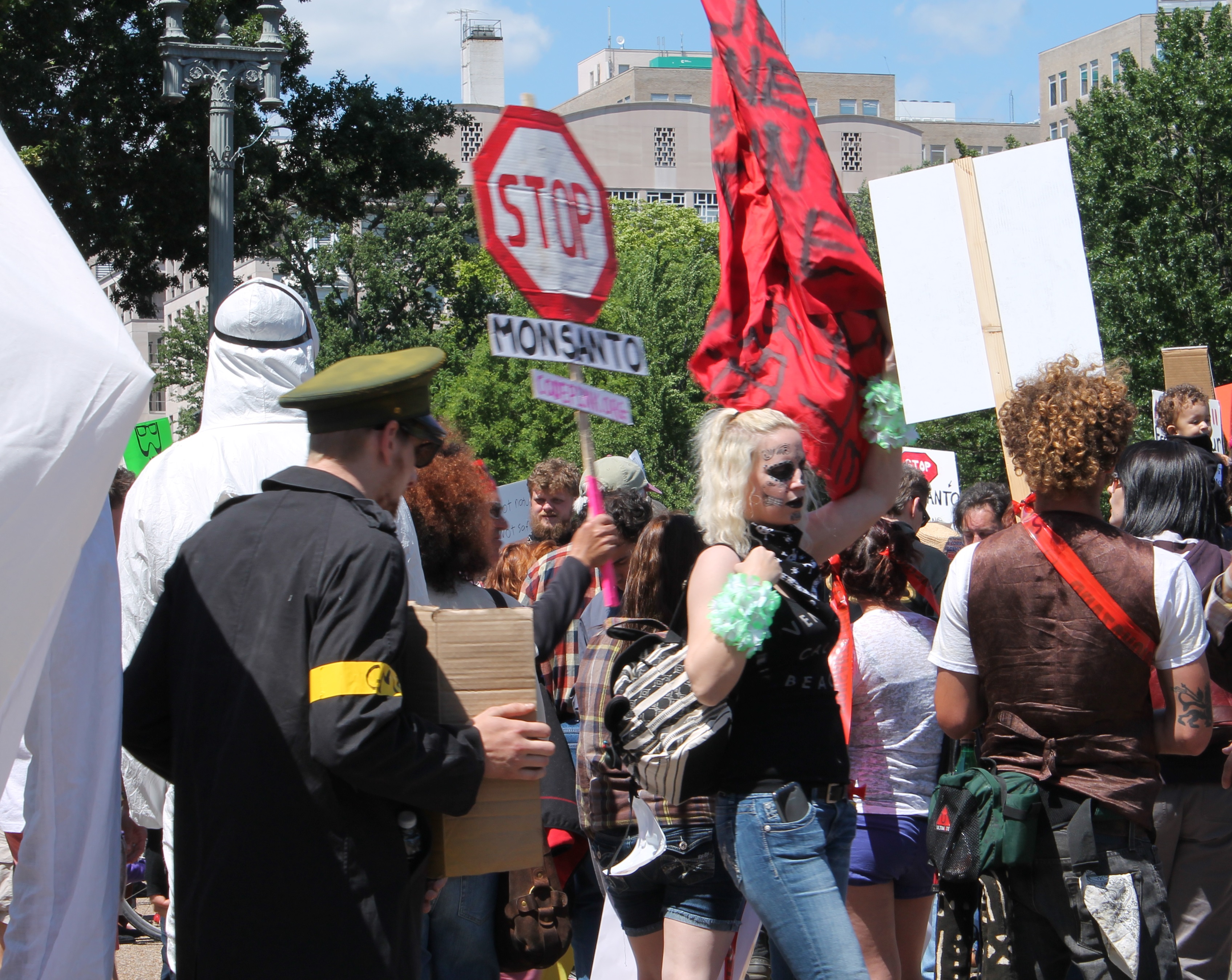 A group of protesters. One holds a stop sign that says "Stop Monsanto".