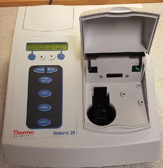 a spectrophotometer with the lid open where a sample is inserted to read absorbance or transmittance