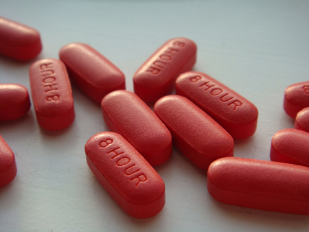 На цій фотографії зображено кілька червоних капсульних таблеток.